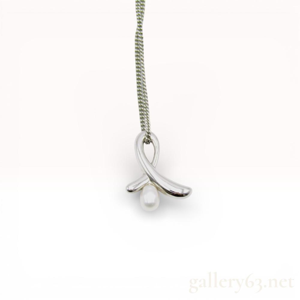 Description
Paloma Picasso for Tiffany and Co. sterling silver Kiss pendant featuring a drop-shaped cultured pearl. The sterling silver pendant is suspended from a Mikimoto sterling silver curb link chain with a spring ring clasp. The reverse of the pendant is marked with a copyright symbol, a Paloma Picasso script signature, T and Co., and 925, while the chain tag bears the Mikimoto M in a shell hallmark.
Length: approximately 16-18 inches.