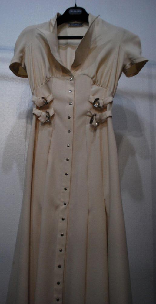 Thierry MUGLER circa 1980

Robe en crêpe ivoire, encolure arrondis sur col découpé, petites manches, effet de taille haute par quatre sangles, boutonnage pression. Taches