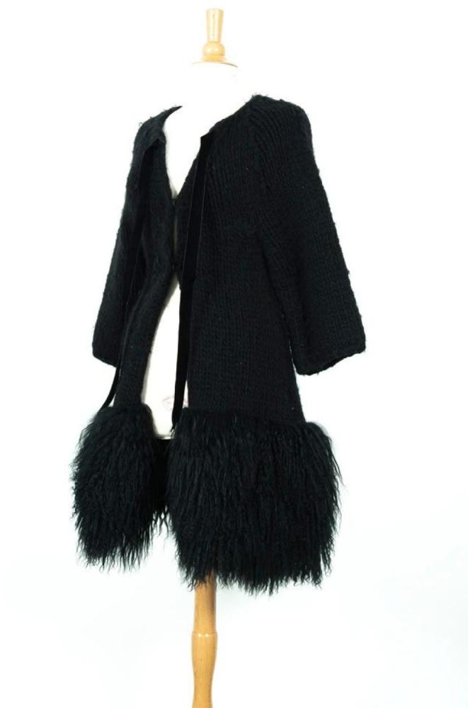 RED VALENTINO

Manteau en lainage tricoté noir, encolure se fermant par un ruban en velours, simple boutonnage à pression sous pattes, bas du manteau gansé d’Agneau de Mongolie en coordonnée. Taille 38/40 environ