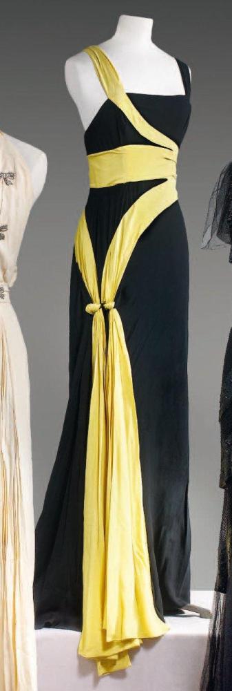 Jean PATOU

Robe longue en crêpe noir, jaune, ce dernier à effet d’entourer le corps finissant sur les hanches par deux noeuds retenant les pans; décolleté carré sur larges bretelles et dos nu, jupe fluide. (modèle de défilé finitions non terminées) Sans griffe Provenance: Garde robe personnelle de Mademoiselle JACK, mannequin de la maison Patou dans les années 1930