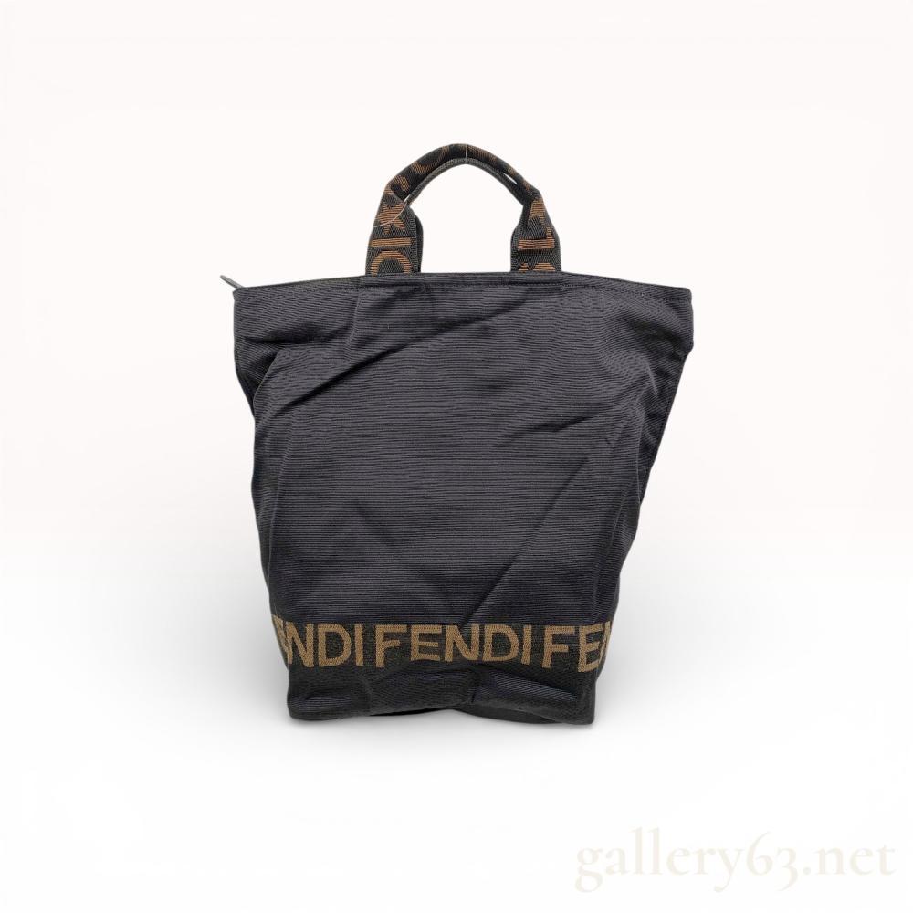Description
Fendi tote bag featuring black ribbed ottoman nylon construction with tan logo accents. The design includes webbed handles with repeating logo and star patterns and a bold Fendi logo across the lower front. It is finished with a zip-top closure, leather pull tab, and leather-piped base.
Height: 15 inches
Width: 12 inches.