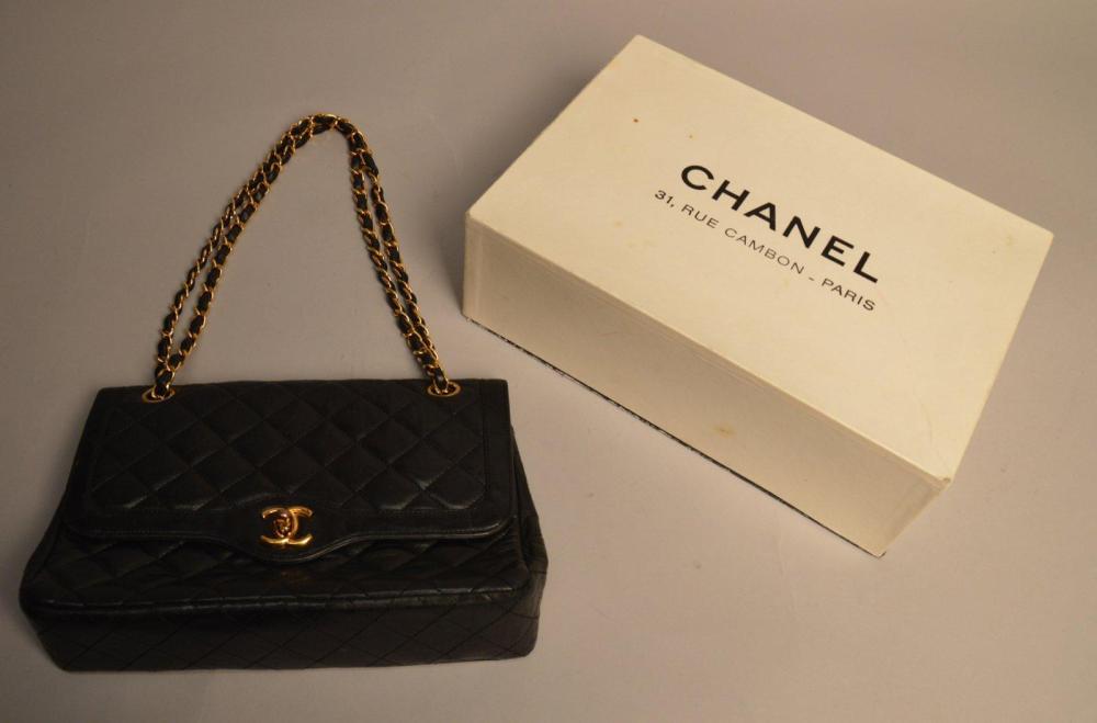 CHANEL

Sac classique en cuir noir matelassé, chaînette en métal doré Avec son dustbag, dans sa boîte d’origine