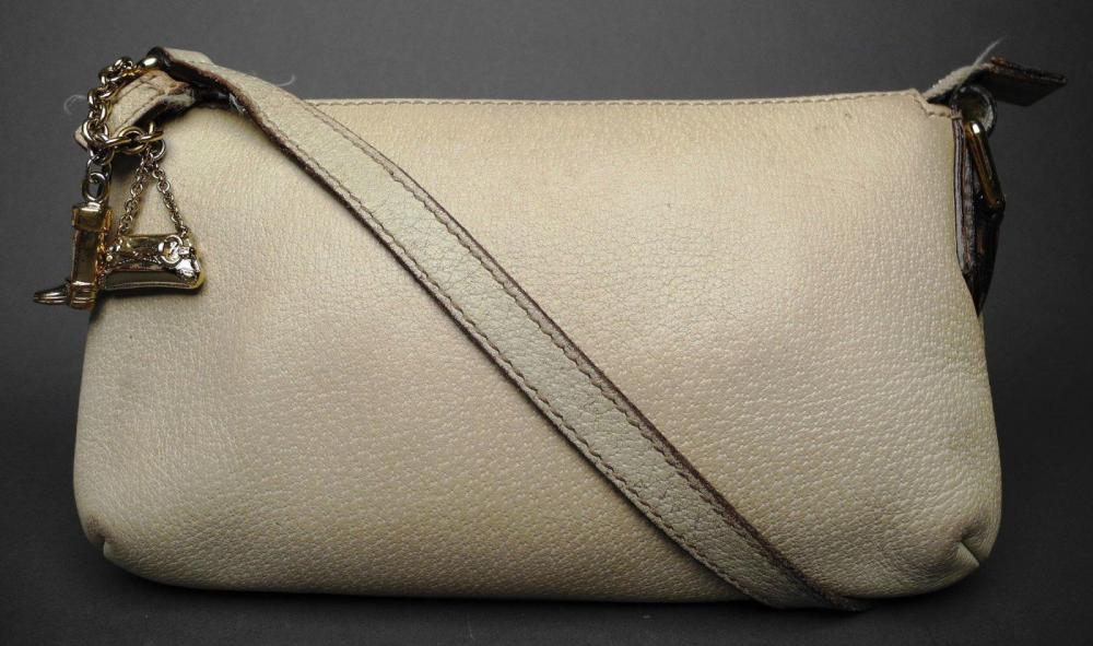 GUCCI

Pochette en cuir grainé beige orné de pendeloques formant un sac et une botte cavalière miniatures en métal doré Fermeture zippée en métal doré L: 23 cm Etat d’usage (usures et salissures)