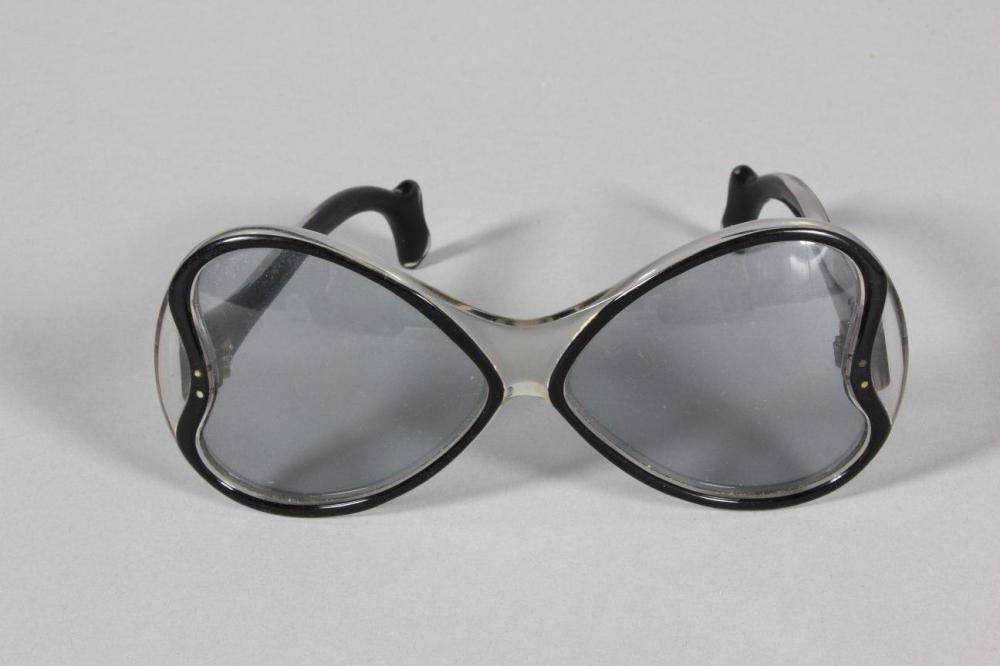 

A pair of Philippe Chevalier sunglasses, probably late 60s-early 70s, with blue-tinted heart shaped lenses; together with a Roberta di Camerino printed velvet case (2)
