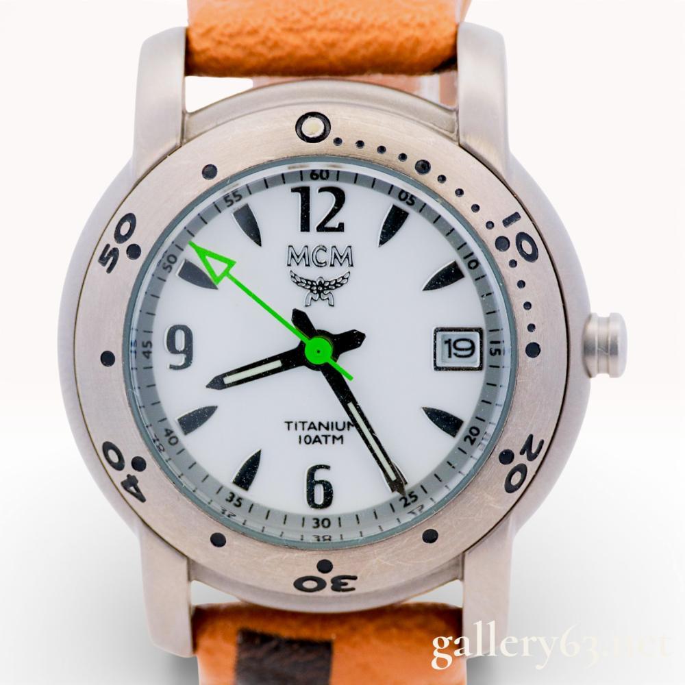 Description
MCM titanium divers-style wristwatch featuring a white dial with black Arabic numerals and a date window at the 3 o’clock position. The watch is designed with a lime green arrow-tipped second hand and is water resistant to 10ATM. It is fitted with an original cognac Visetos logo leather strap and includes the original branded presentation box.
Case size: 34-36mm.