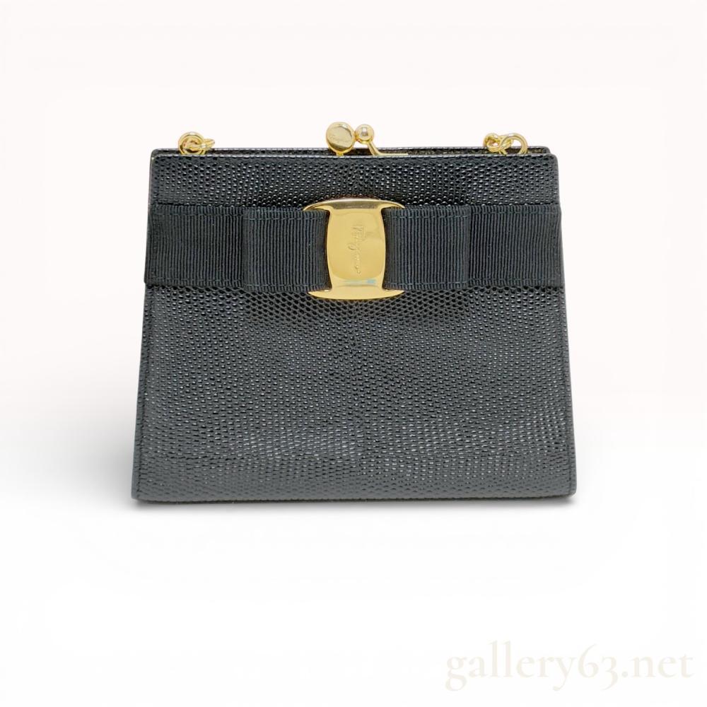 Description
Salvatore Ferragamo mini shoulder bag having a structured rectangular shape and hinged metal frame closure. Featuring black textured leather exterior set with the signature grosgrain Vara bow and gold-tone logo plate at the front. Having a gold-tone chain shoulder strap attached to metal loops at the top. Interior lined in dark fabric with a single compartment and small slip pocket.