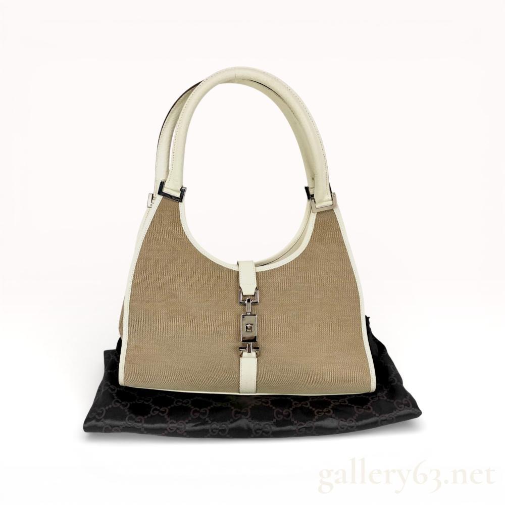 Description
Gucci Piston Lock Bardot hobo bag featuring a woven tan canvas body with off-white pebbled leather trim and dual rolled handles. The exterior is accented with silver-tone hardware including a signature piston-style clasp engraved with the Gucci name. The interior is lined in dark brown monogram textile with one zippered pocket and includes a black monogram dust bag.
Width: 12 inches.