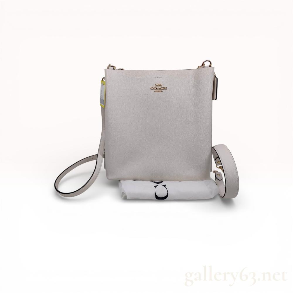 Description
Coach Kitt Messenger bag in chalk-colored pebbled leather with a contrasting mauve interior, style number CA214. The bag features gold-tone hardware, a front slip pocket with a magnetic snap closure, and a top-zip main compartment. Branded elements include the horse and carriage logo on the front and an interior storypatch with serial number B2379-CA214, indicating a February 2023 production date.
Approximately 8.25 inches width x 8.25 inches height x 1 inch depth.