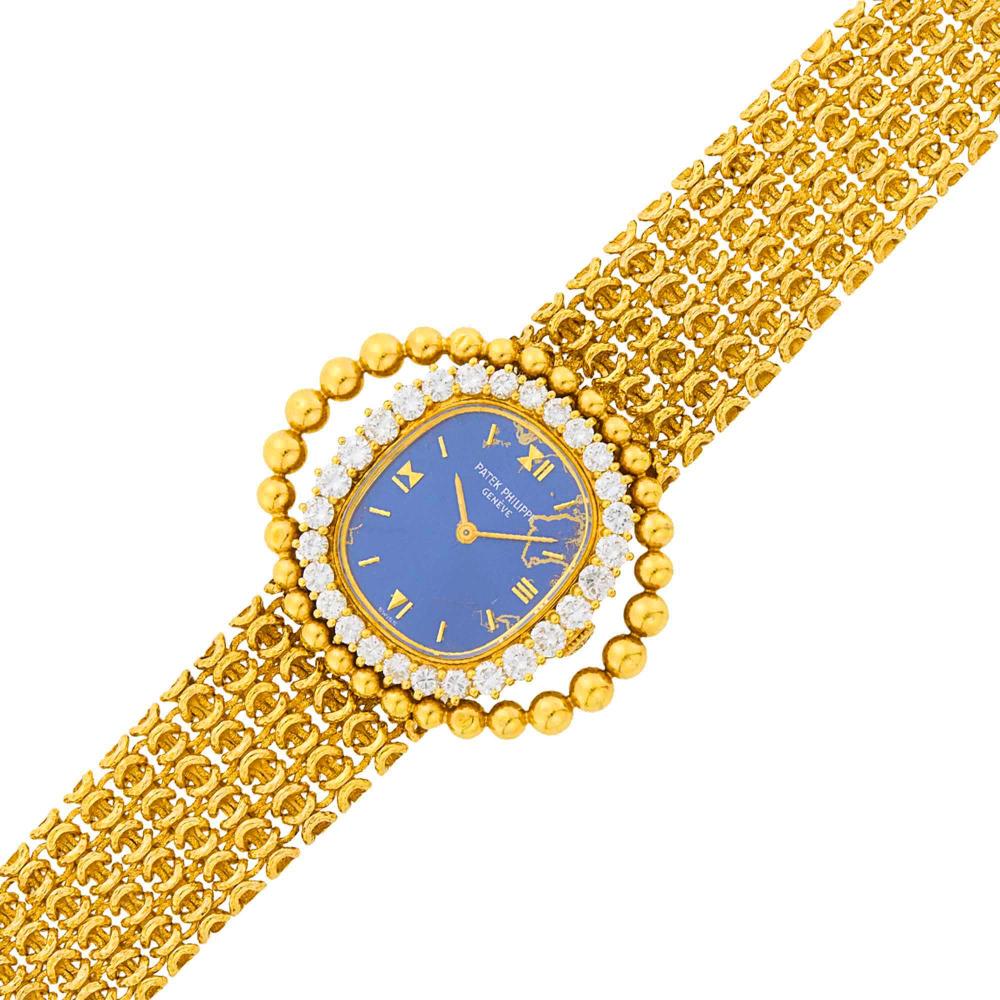 Property of a Distinguished Lady from Athens, Greece18 kt., mechanical, cushion-shaped brushed blue dial, applied gold Roman numerals at the quarter hour and bar markers, 28 round diamonds ap. 1.65 cts., outer graduated ball frame, sapphire crystal, logo crown, inner case diameter ap. 26 x 23 mm., outer diameter ap. 29.5 x 34 mm., five row textured and hammered and polished link bracelet with fold-over clasp, dial, movement, case and buckle signed Patek Philippe, movement no. 1260000, case no. 2715294, dial damaged, ap. 39 dwts. gross. Length 5 3/4 inches, adjustable.

The movement is currently running, but not guaranteed to be in working order. 18J. 5 Pos.The blue on the dial is worn off between 11:00 and 12:00, 1:00-2:00 and 4:00.Diamonds: G-H-I-VS.Inner case diameter 1 x 15/16 inch. Outer diameter 1 3/16 x 1 3/8 inches.Bracelet width 5/8 to 9/16 inch.                            
Any condition statement is given as a courtesy to a client, is an opinion and should not be treated as a statement of fact and our Organization shall have no responsibility for any error or omission. Please contact the specialist department to request further information or additional images that may be available.