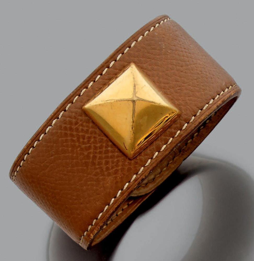 HERMES

Bracelet de cuir marron rehaussé d’un motif clou doré. Signé