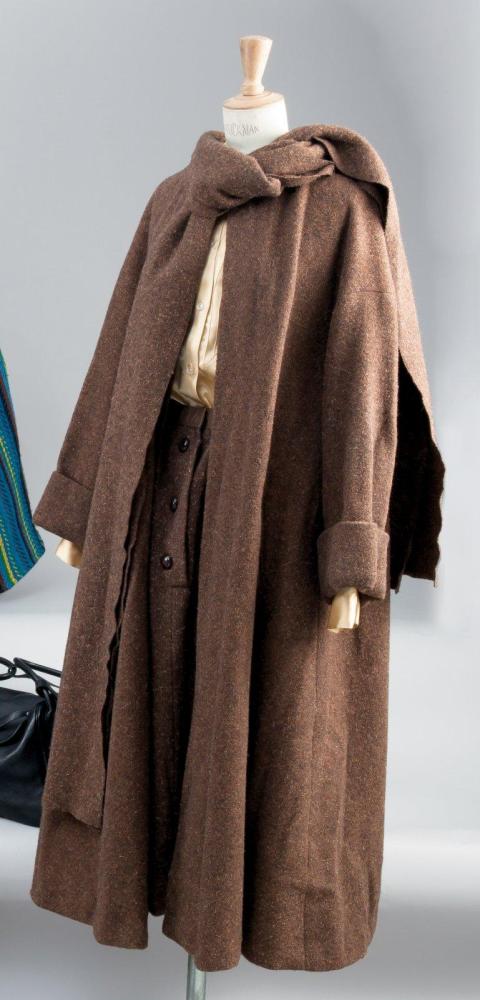 Guy LAROCHE

Haute couture circa 1958 Ample manteau en tweed chiné marron encolure ronde sous écharpe, parementures sans boutonnage, manches longues à emmanchures basses, deux poches biais, se porte sur une jupe à taille foncée à l’identique et une blouse de satin champagne. Griffe blanche, graphisme noir sur le manteau