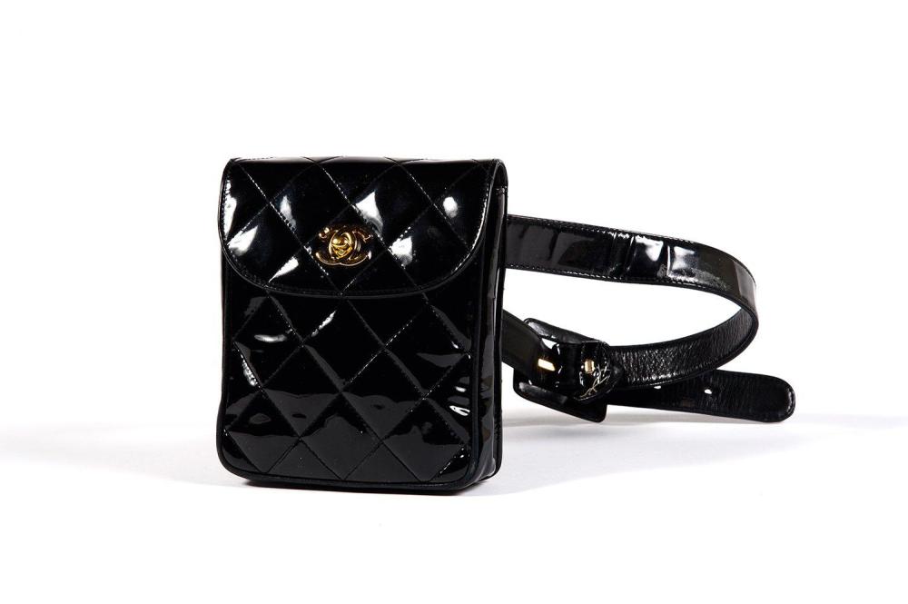 CHANEL

Pochette - ceinture en cuir vernis matelassé noir, fermoir en métal doré siglé sur rabat. T.75. Bon état (usures, salissures)