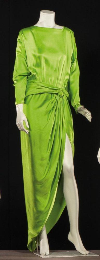 Pierre CARDIN, Haute-couture, circa 1980

Robe du soir longue en soie verte pistache, haut à décolleté bénitier sur dos ouvert, manche chauve-souris à poignets resserrés, taille souligné de deux pans retenant le drapé de la jupe, fente de côté arrondie. Griffe blanche, graphisme noir. (petits fils tirés)