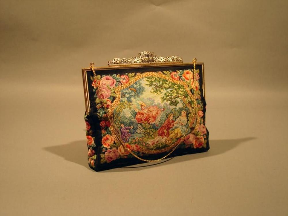 ANONYME Petit sac en tapisserie à motif...

ANONYME
Petit sac
en tapisserie à motif de scènes galantes, armatures en métal doré, fermoir métal argenté, sculpté repercé agrémenté de perles blanches, anse chaîne