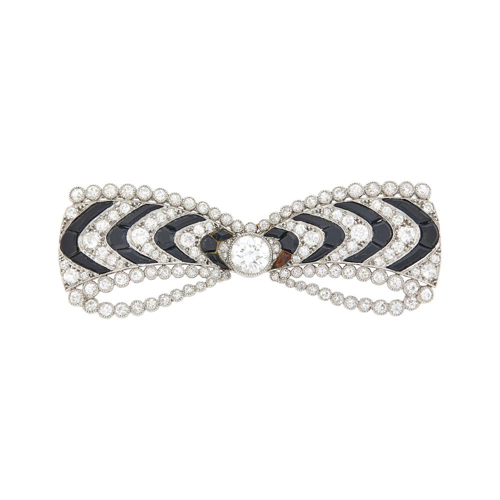 From the Estate of a Life-Long Upper East Side WomanOne old European-cut diamond ap. .50 ct., small old European and single-cut diamonds ap. 1.90 cts., fancy-shaped black onyx, no. 7301, with French assay mark, circa 1920, ap. 7.6 dwts.

Center diamond: H-I-VS.Nicely made. 2 1/8 x 3/4 inches.                            
Any condition statement is given as a courtesy to a client, is an opinion and should not be treated as a statement of fact and our Organization shall have no responsibility for any error or omission. Please contact the specialist department to request further information or additional images that may be available.