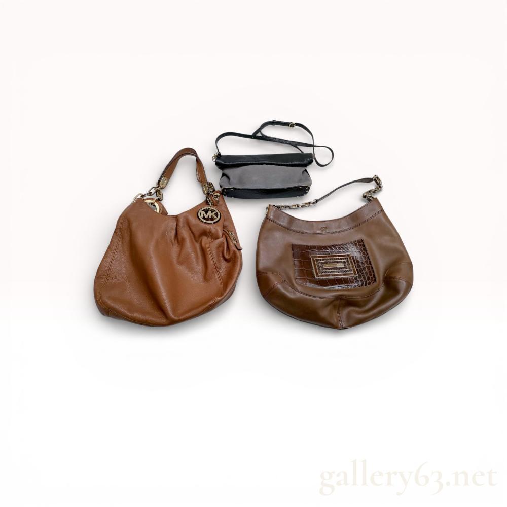 Description
Three leather handbags in mixed brands/styles. Includes two medium brown shoulder bags with slouchy hobo silhouettes, gold-tone hardware, chain or leather shoulder straps, one with front patchwork/embossed panel detail. Also includes small black crossbody/shoulder bag with slim strap and zip-top closure. Mixed interiors with fabric lining and pockets. Visible creasing, scuffs, wear consistent with use across pieces. Michael kors and See by Chloe.