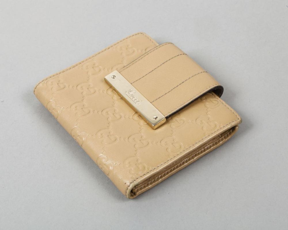 GUCCI

Portefeuille, porte cartes, porte-monnaie en cuir siglé beige, fermeture languette sur pression. Bon état.