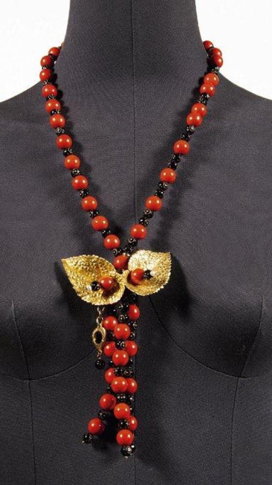 Yves SAINT LAURENT

Sautoir composé de perles rouges, noires ornées de filets or, agrémentées de deux feuilles en métal doré. Signé.