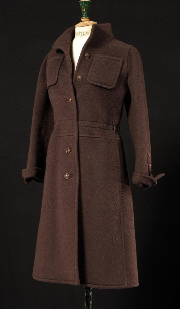 Emanuel UNGARO

Couture N°2896, Automne - Hiver 1974 Manteau en cachemire marron a effet de surpiqûres, deux poches poitrines plaquées, et deux poches dans les coutures, simple boutonnage à cinq boutons, manches longues à revers, fente dos. Griffe blanche, graphisme noir (manque la ceinture)