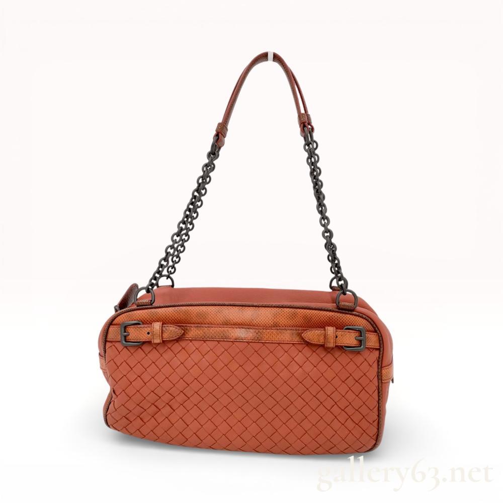 Description
Bottega Veneta chain shoulder bag featuring signature intrecciato woven leather and exotic lizard skin trim. The terracotta-colored leather body is accented with gunmetal-tone chain straps, buckle details, and a taupe-gray suede-lined interior. An interior leather tab is embossed with the mark BOTTEGA VENETA MADE IN ITALY.
11.5 inches (W) x 6.5 inches (H) x 4 inches (D).