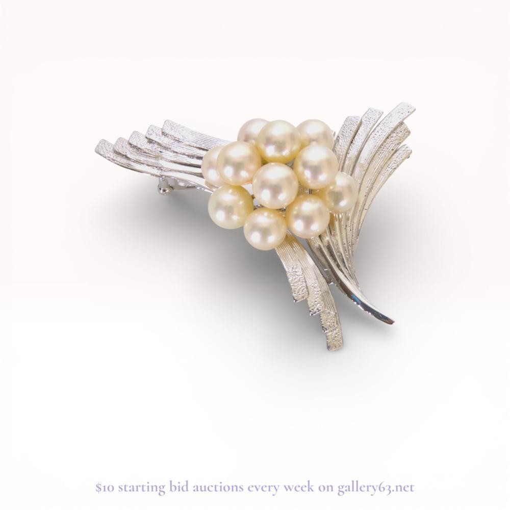 Description
Japanese mid-century modern spray brooch featuring a central cluster of eleven cultured pearls. The silver metal rays exhibit alternating textured and polished finishes, fanning out from a central raised setting. The reverse is stamped SILVER on a circular stabilizer plate and includes a horizontal pin with a revolving safety catch.
60mm x 50mm.
