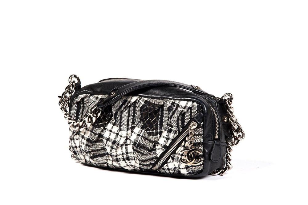 CHANEL

Sac 23cm en lainage noir et blanc à effet de carreaux et cuir agneau noir, devant orné d’un zip retenant le sigle de la Maison, fermeture éclair, demi anse bandoulière chaîne en acier chromé se continuant sur le pourtour du sac, patte d’épaule. Bon état