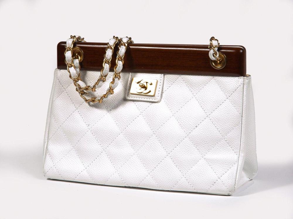 CHANEL

Sac 22cm en cuir grené et cuir grené matelassé blanc, armature rigide aimantée en bois, sigle en métal doré brossé, double demi-anse bandoulière chaîne entrelacée de cuir en coordonné. Bon état