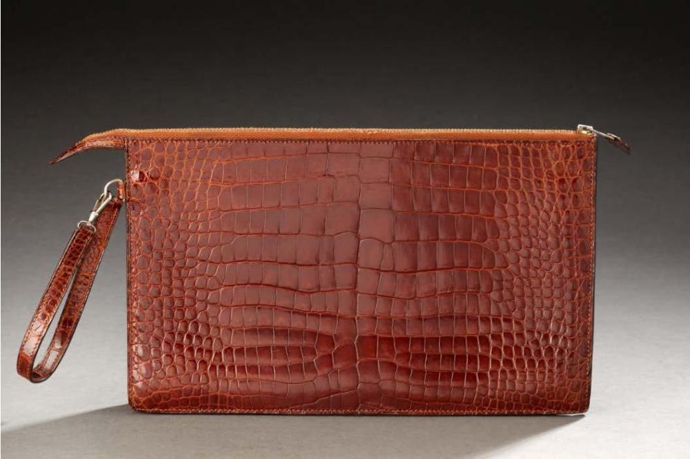 HERMES

Pochette zippée compartimentée en crocodile marron, attache poignet. 17 X 27 cm env. Bon état