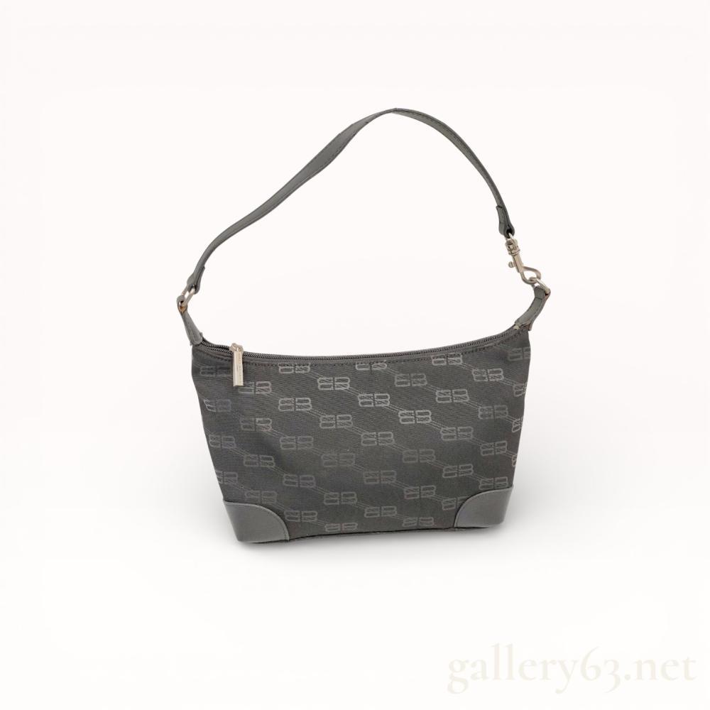 Description
Balenciaga shoulder bag featuring the signature BB monogram pattern in charcoal grey and black. The bag is crafted from jacquard canvas with black leather-style trim, reinforced corners, and silver-tone metal hardware. It features a tapered rectangular silhouette with a detachable flat shoulder strap and a top zipper opening to a black fabric-lined interior with one zippered pocket. The hardware is engraved with Balenciaga and the interior contains a fabric tag marked Made in China.
Width at base: 9 inches.