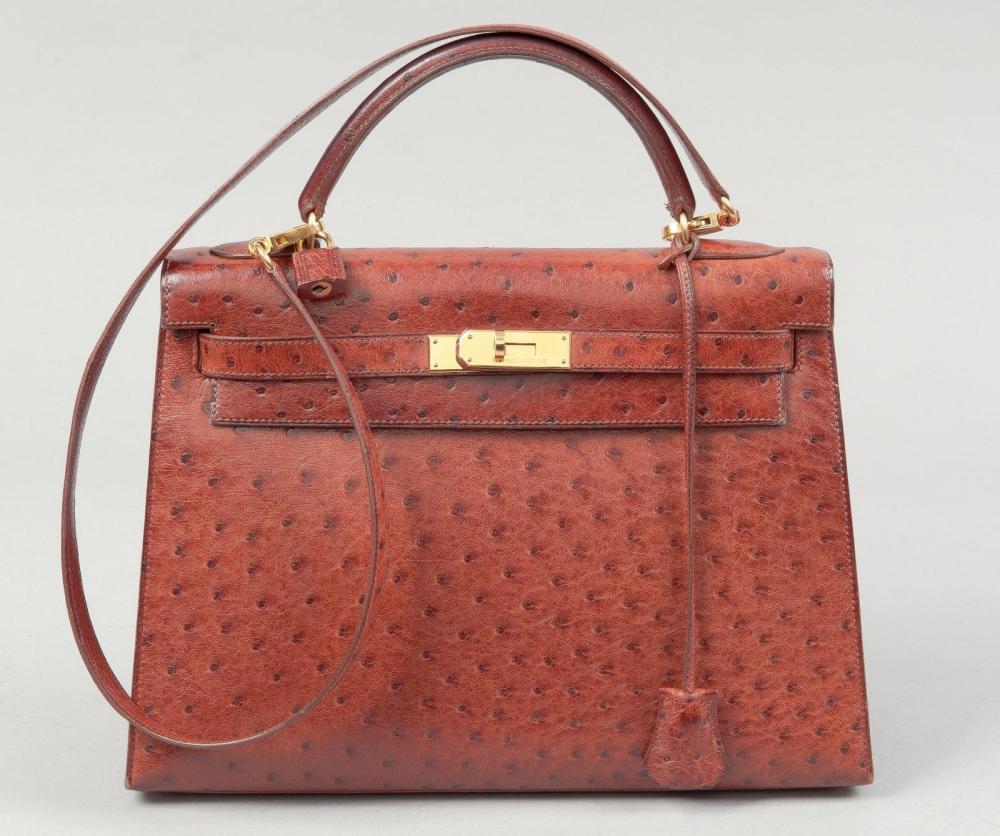 HERMES Paris made in France

Sac "Kelly" 33 cm en cuir autruche cognac, attaches fermoir plaqué or, poignée, clefs cadenas recouvert, anse bandoulière. (Tâches à l’intérieur, légères usures aux coins). Bon état.