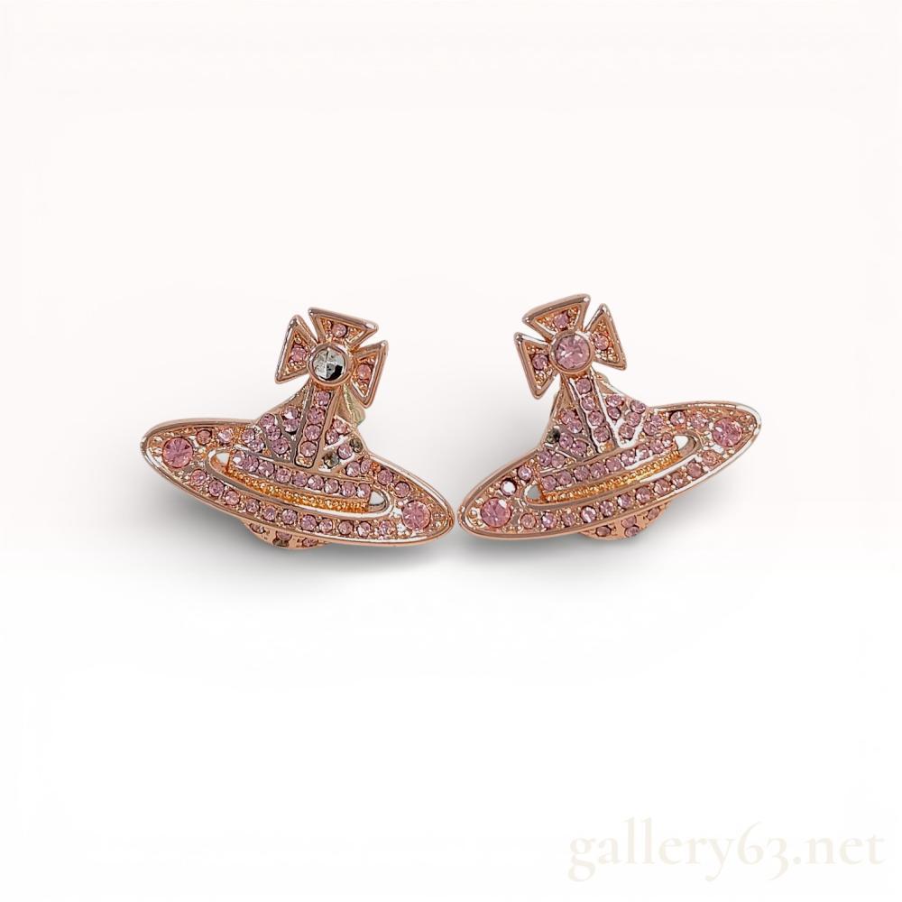 Description
A pair of designer stud earrings by Vivienne Westwood featuring the signature Orb and Saturn Ring motif. The pieces are constructed from rose gold-tone base metal and are pavé-set with numerous round-cut light pink crystals, with a larger clear crystal set into the center of the cross. The earrings feature post and butterfly friction backings. The reverse of each earring is stamped with the hallmark © Vivienne Westwood. This set includes a Vivienne Westwood branded presentation box and a cream-colored cloth drawstring pouch. Each earring measures approximately 25mm wide by 17mm tall. Total weight: 7.2 grams.