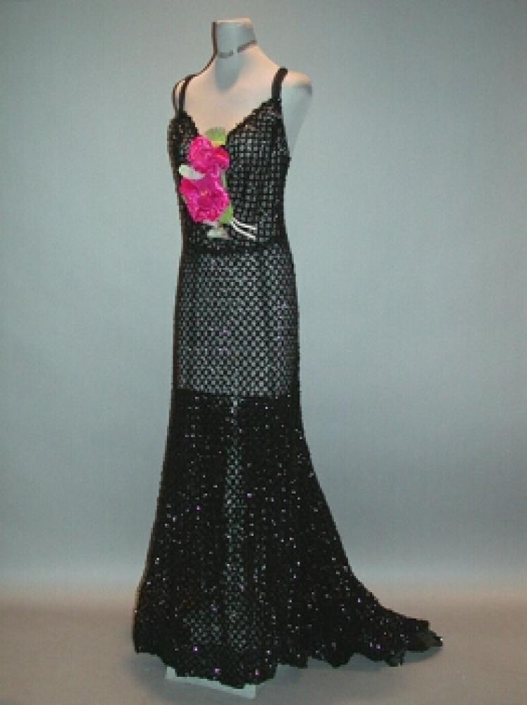Black Ring Pattern Sequined Evening Dress

Lot 519
Black Ring Pattern Sequined Evening Dress
 Attributed to Worth, French, 1930s 
 With sweetheart neckline, low V back, square train, of black tulle embroidered with black sequins, front pink velvet and silk flower, size 6. 
Excellent condition.