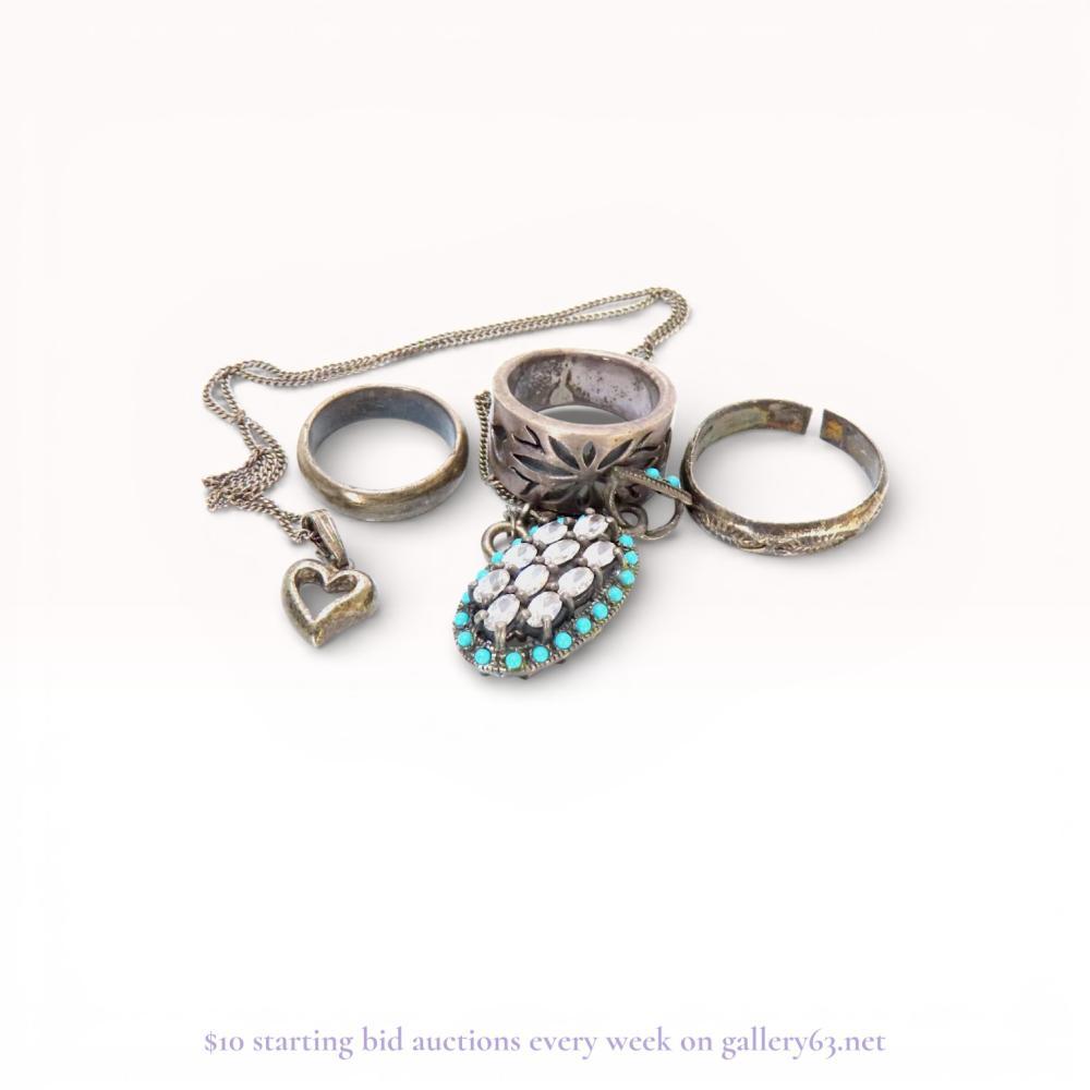 Description
A jewelry collection featuring a heart pendant necklace, an ornate oval cluster pendant, and three assorted rings. The oval pendant is designed with twelve faceted clear stones surrounded by turquoise-colored cabochon beads in a style resembling Navajo cluster jewelry. The heart pendant is stamped 925, and the rings include a wide floral cutout band and a simple rounded band.
Oval pendant length: approximately 2.5 cm.