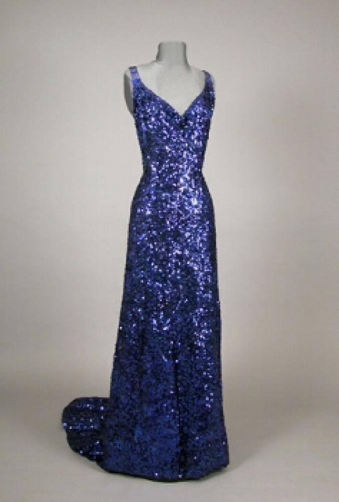 Sapphire Blue Sequined Evening Gown

Lot 518
Sapphire Blue Sequined Evening Gown
 Attributed to Worth, French, 1930s 
 With low V front and back, blue stone straps, square train, mousseline embroidered with shamrock-shaped sequins, size 8. 
Excellent condition, several breaks in straps.