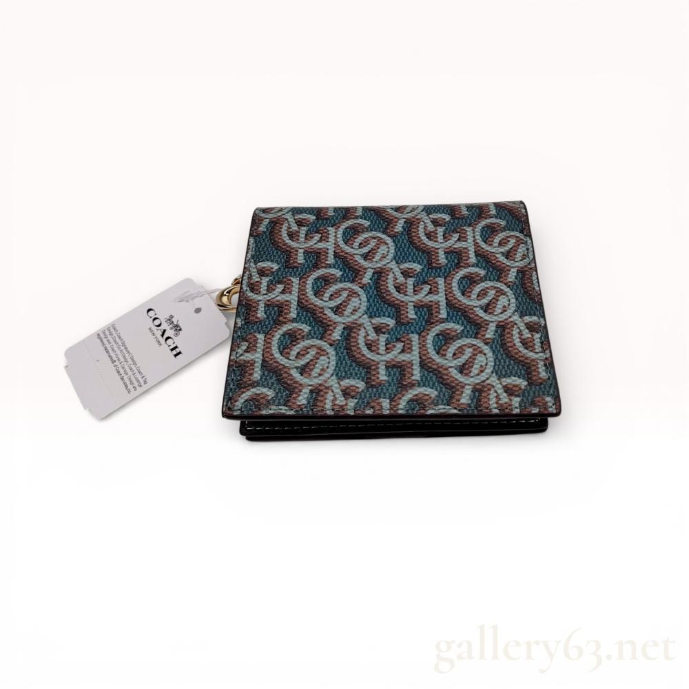 Description
Coach bifold wallet in signature monogram coated canvas with a smooth leather interior, model CF522. The design features a snap-closure bifold section containing one ID window, three credit card slots, and a full-length bill compartment, complemented by an exterior zip-around coin pocket. Polished gold-tone hardware includes a decorative C logo charm on the zipper pull and an embossed snap button.
Length: 4 inches
Height: 3.75 inches.