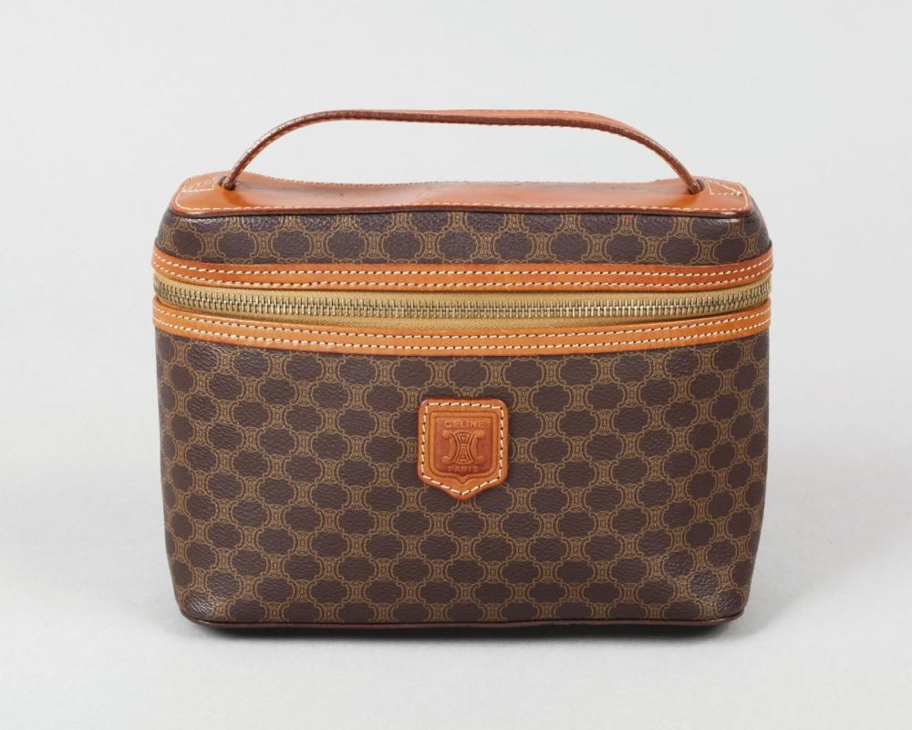 CELINE

Pochette accessoire en toile siglée marron et cuir en coordonné, fermeture éclair, poignée. Bon état (légères égrenures).