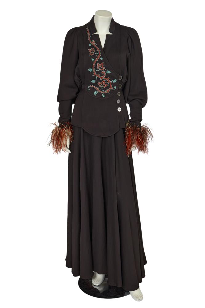 A Bill Gibb brown silk-blend ensemble, circa 1973

A Bill Gibb brown silk-blend ensemble, circa 1973

labelled, the blouse with wide curved panel to the front right, embroidered with teal and orange chainstitch ivy motifs, crossing to button closure on left side of waist, the full dolman sleeves edged with orange and brown ostrich feathers to the cuffs, lined in purple acetate, bust 86cm 34in; the matching full circle skirt with acetate lining, waist 66cm 26in (2)

Share this lot: