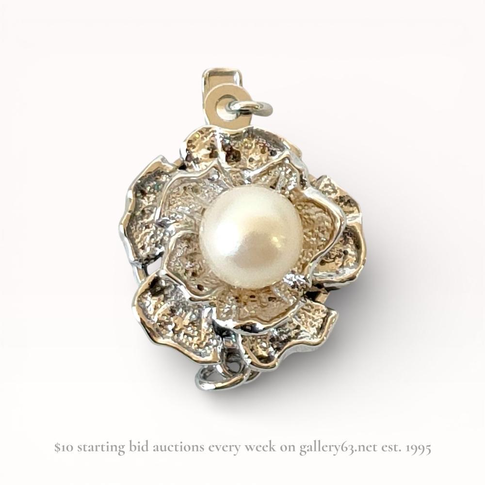 Description
Vintage silver floral jewelry clasp, mid-to-late 20th century. Stylized camellia blossom design featuring textured, layered petals and a center-set 6.5mm to 7mm cultured pearl with creamy white luster. Constructed with a box and tongue mechanism and a safety fishhook for multi-strand use; the reverse is stamped SILVER.
Diameter: 15mm
Total Length: 22mm.