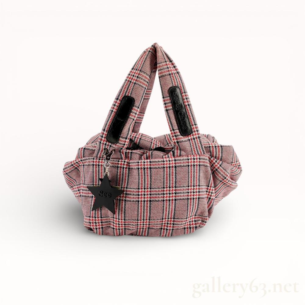 Description
See by Chloe Joy Rider style puffed tote bag featuring a red, white, and navy blue houndstooth plaid knit exterior. The design includes integrated top handles with black leather brand patches, a black fabric-lined interior, and an oversized black zipper closure. A large black star charm embossed with See is attached to the front handle base. Brand marks are visible on the leather handle patches and the main zipper pull.
Base Width: 12 inches
Height: 8-9 inches.
