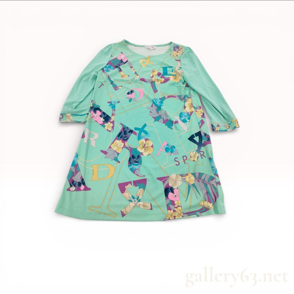 Description
Leonard Sport tunic top featuring mint green polyester fabric with multicolor graphic and floral print throughout.


A-line silhouette having a wide crew neckline and three-quarter length sleeves.


Front featuring oversized abstract lettering and botanical motifs in pastel tones.


Soft lightweight knit construction with smooth finish.


Interior neck bearing Leonard Sport label, size 38.