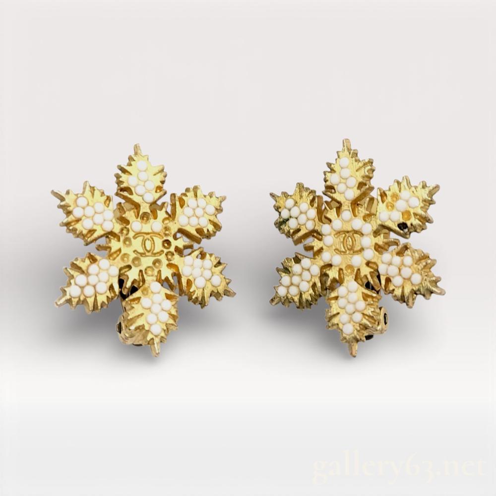 Description
Chanel snowflake-shaped earrings from the 01A collection, featuring gold-tone metal construction. Each earring formed as a six-point snowflake motif composed of layered, leaf-like elements set with clear rhinestones. Textured and polished surfaces create contrast throughout the design. Clip-back closure at the reverse. Signed Chanel on the fittings.