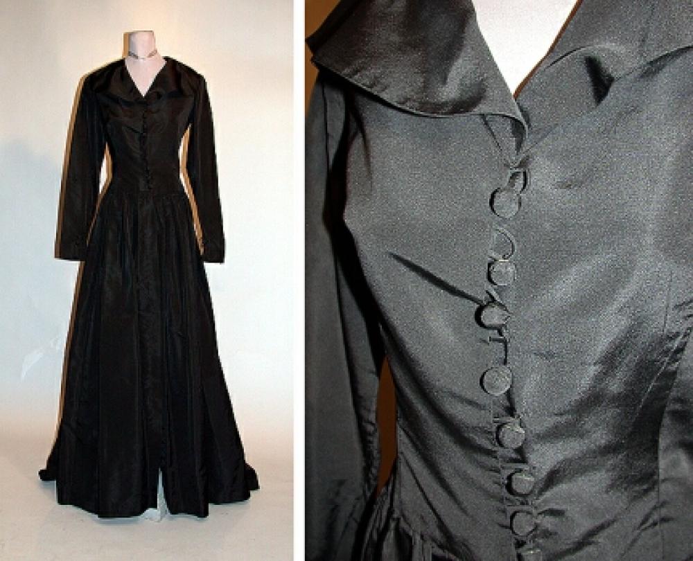 Molyneux At-Home Gown

Lot 525
Molyneux At-Home Gown
 French, late 1940s 
 Of black silk taffeta, bodice fitted, with V-neckline framed by large rounded collar split at shoulders, the sleeves long and tight, the shoulders padded, button and loop closures down front to waist, the skirt floor length and opened at front, lengthening into train at back, gathered into waist and around back to central en fourreau back panel, size 8, labeled: Molyneux.
Very good condition.