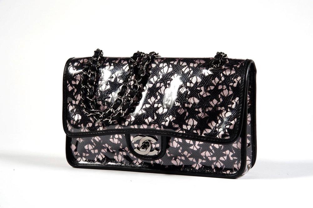 CHANEL

Sac 25 cm en PVC gansé de cuir agneau noir et cuir métalisé rose rehaussé de broderies figurant des étoiles, fermoir siglé en acier chromé sur rabat, anses bandoulières chaînes réglables entrelacées de cuir en coordonné, poche extérieure. Bon état