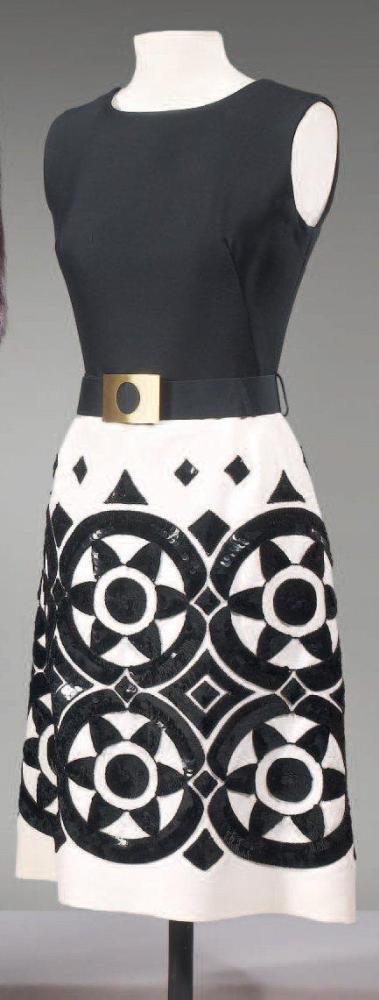 VALENTINO (attribué à)

Robe de cocktail, haut en soie noire à encolure bateau, sans manches, jupe évasée en soie écrue rebrodée de paillettes à motifs circulaires et géométriques, taille soulignée d’une ceinture à boucle dorée