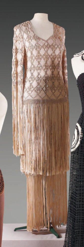BATTILOCCHI, circa 1970

Ensemble en rubans de soie greige travaillé façon macramé composé d’un haut à décolleté en pointe, bas des manches longues et de la tunique finissant par des franges, jupe droite longue à taille coulissée à l’identique Griffe blanche, graphisme noir