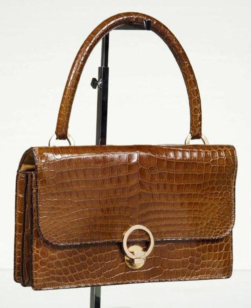 HERMES PARIS

Sac "Ring" en crocodile porosus camel à deux soufflets, attaches et fermoir sur rabat plaqué or, poignée. Bon état (traces de stylo, taches intérieures, usures aux coins)