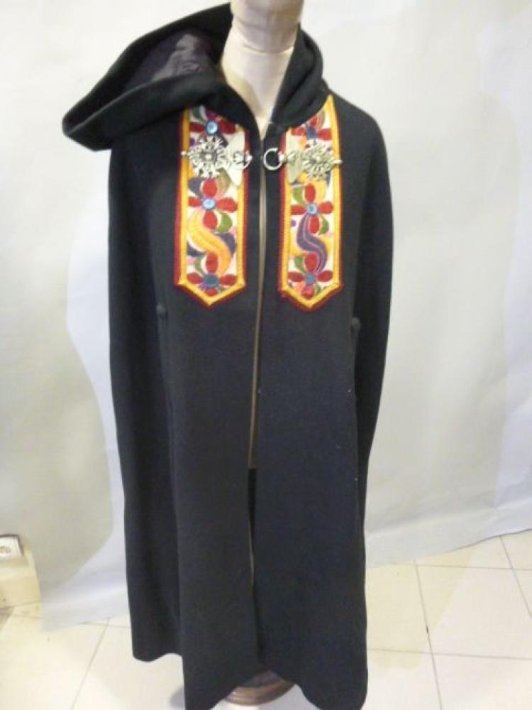 Grande cape brodée à capuche, beau fermoir...

Grande cape brodée à capuche, beau fermoir façon argent martelé. Laine noire et broderies de coton polychrome
