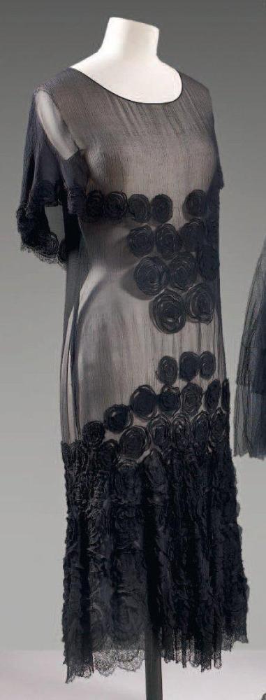 Anonyme

Robe en mousseline noire, ornée de roses en application de même tissu, encolure ronde, effet de cape au dos tombant sur les épaules rappelant le motif arrondi soulignant la poitrine, jupe fluide avec rappel des fleurs à foison rsur finition de dentelle de Chantilly