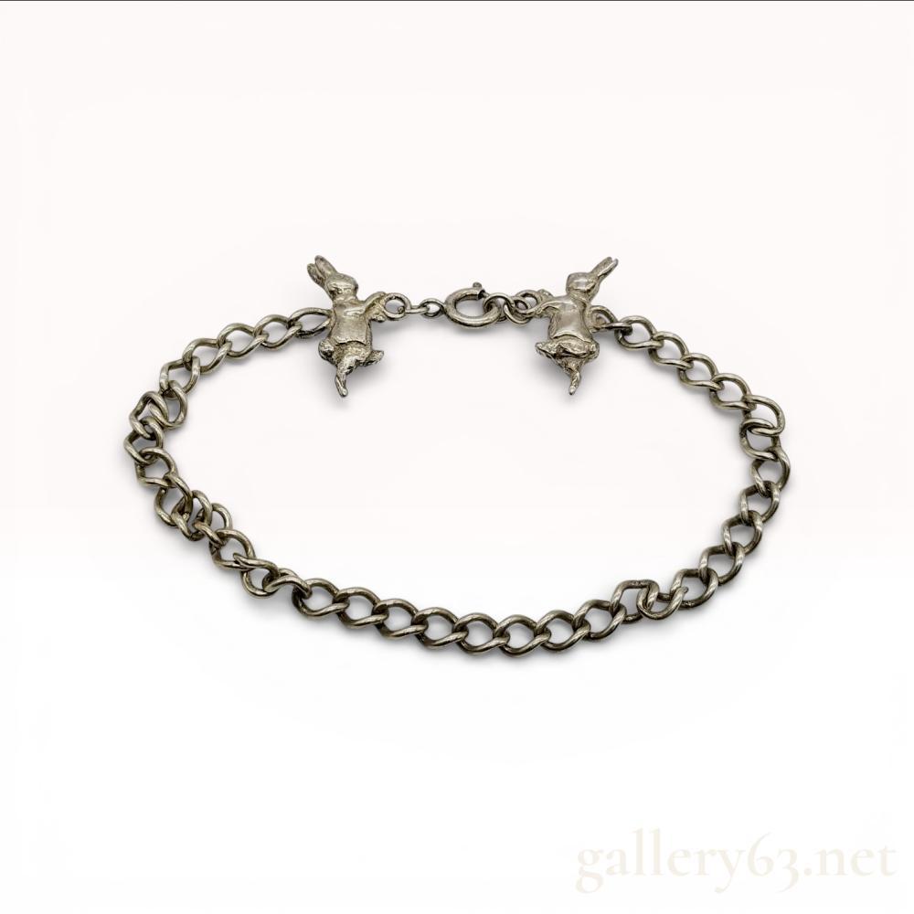 Description
Sterling silver curb link bracelet featuring two integrated figural rabbit charms by the maker Kite. The charms are depicted in active poses and flank a spring ring clasp. One charm is incised with the mark KITE and a 925 hallmark, while the clasp is stamped STERLING.
Length: 19 cm
Interior Circumference: 17 cm - 18 cm.