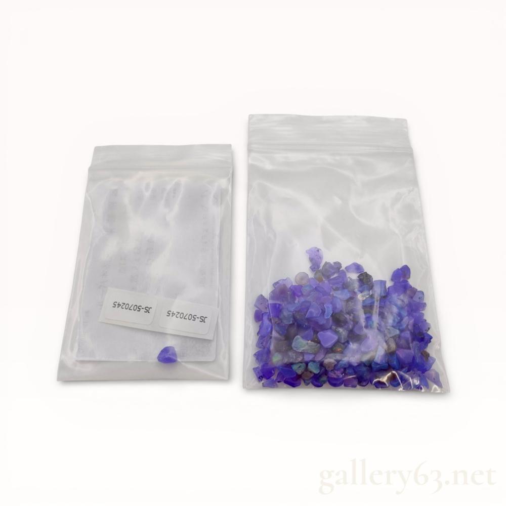Description
An assortment of natural purple opal rough and tumbled stones, including one specimen with a Japan Gemstone Science Laboratory (JSL) identification report. The stones feature a translucent violet to purple body color with a waxy luster, and several pieces exhibit iridescent flashes of green and blue play-of-color. The certified stone is identified by JSL report number JS-5070245, while the remaining stones in the collection are of similar material.
Certified stone: 5.53 x 5.28 x 4.26 mm
Certified stone weight: 0.47 ct.